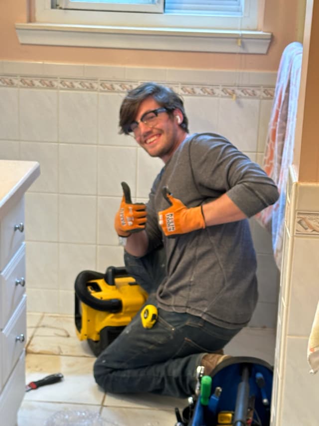 Toilet Guys technician giving thumbs up during a toilet installation in Grosse Pointe, MI